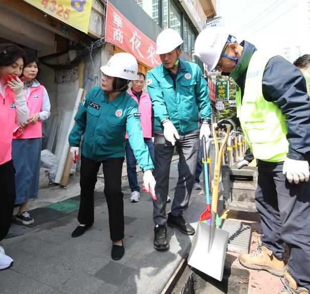 올해 4월 24일 박희영 용산구청장(왼쪽에서 3번째)가 이촌1동 빗물받이 준설 현장에서 주민에게 빗물받이 퇴적물을 보이며 설명 중이다