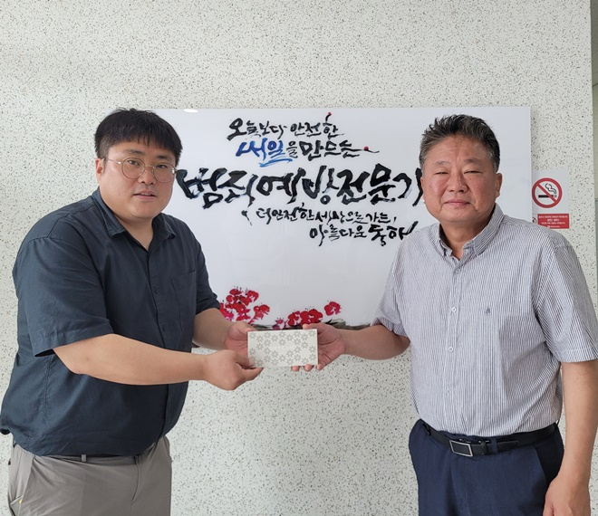 2분기 친절직원으로 선정된 이현우 주임(사진왼쪽)이 지부장으로부터 선물을 받고 기념촬영.(사진제공=한국법무보호복지공단 경부지부)