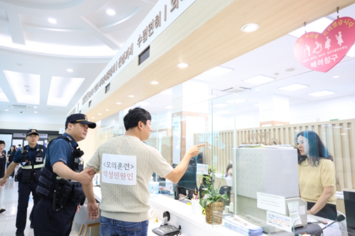 민원인이 경찰 앞에서 구청 직원들에게 폭언을 하고 있다.