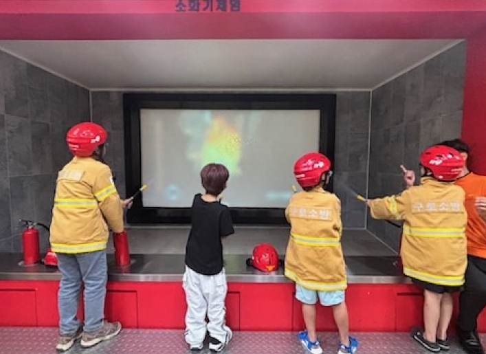 아이들이 구로소방서에서 소화기 사용법을 체험을 하고 있다.