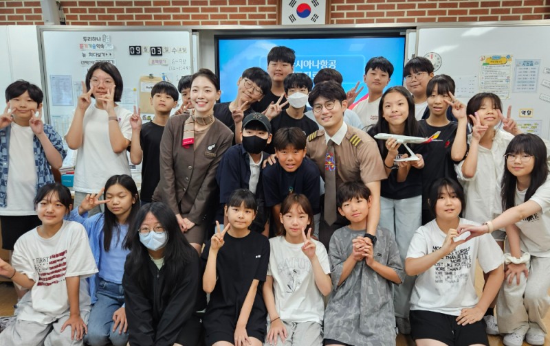 3일(수) 서울공진초등학교에서 열린 항공진로 직업특강에서 (왼쪽부터)이민정 부사무장, 이동준 부기장이 학생들과 기념촬영을 하고 있다.(사진=아시아나항공)