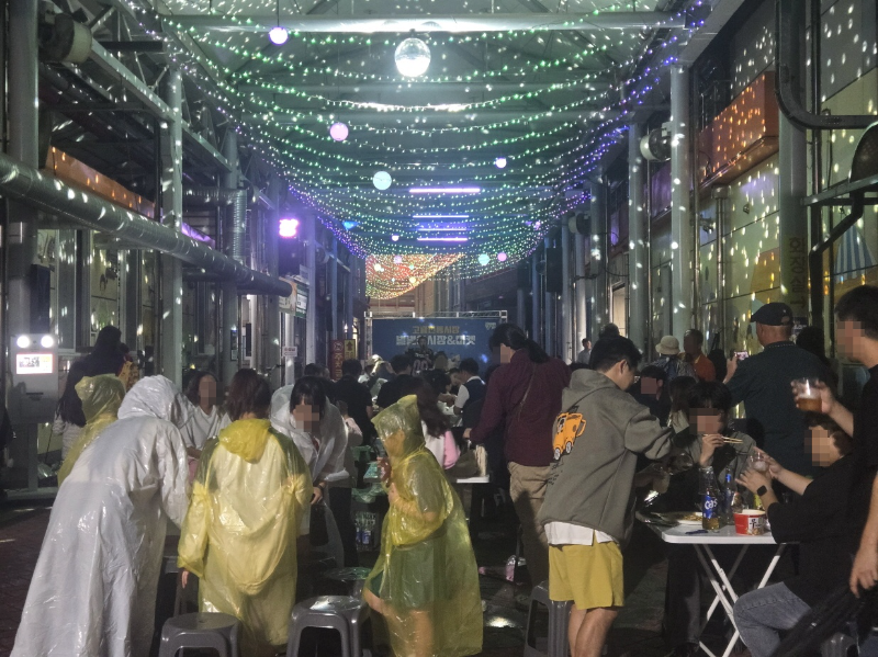 ▲고흥전통시장 천변 일원에서 열린 ‘별별야시장’이 비가 내리는 가운데도 많은 인파가 몰리며 지역 상권이 살아 숨 쉬는 야간축제 행사로 거듭나고 있다. (사진=고흥군청 제공)