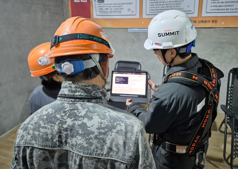 호반건설 직원이 건설 현장에서 AI 동시번역 플랫폼 ‘호반커넥트’를 활용해 근로자들과 대화하고 있다.(사진=호반건설)