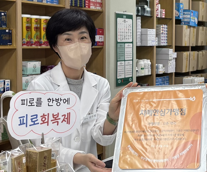 철마면 고촌약국 김수정 대표가 기장군 치매안심가맹점 지정 현판을 전달받고 있다.(사진제공=부산 기장군)