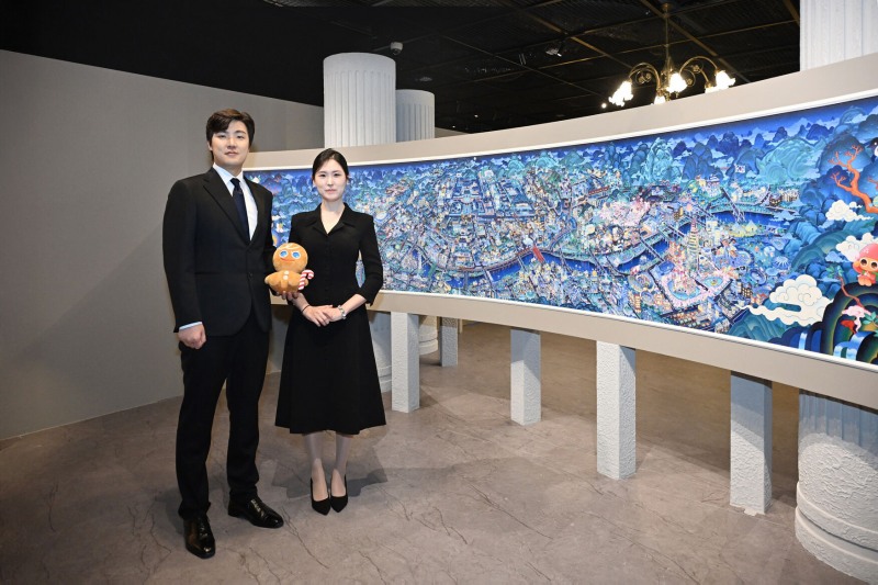 데브시스터즈 조길현 대표(좌)와 이은지 CIPO(우)가 '쿠키런 상상화 3: 꺼지지 않을 희망의 빛' 작품 앞에서 기념 촬영을 하고 있다. 사진=데브시스터즈