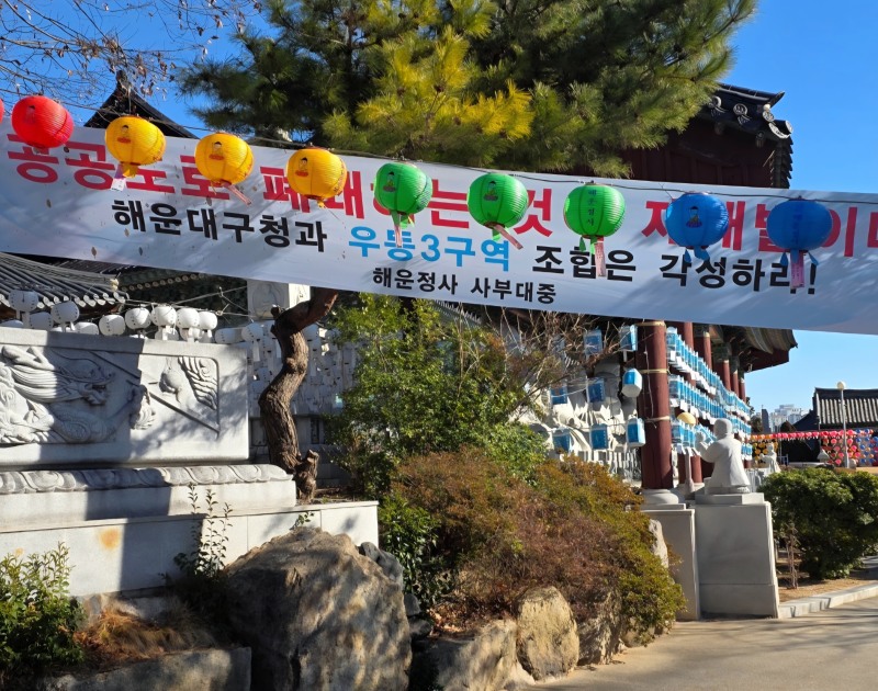 해운대 해운정사 사찰 정문 입구에 우동3구역 재개발 관련 행정미비를 규탄하는 현수막이 걸려있다./ 사진=이승렬 기자