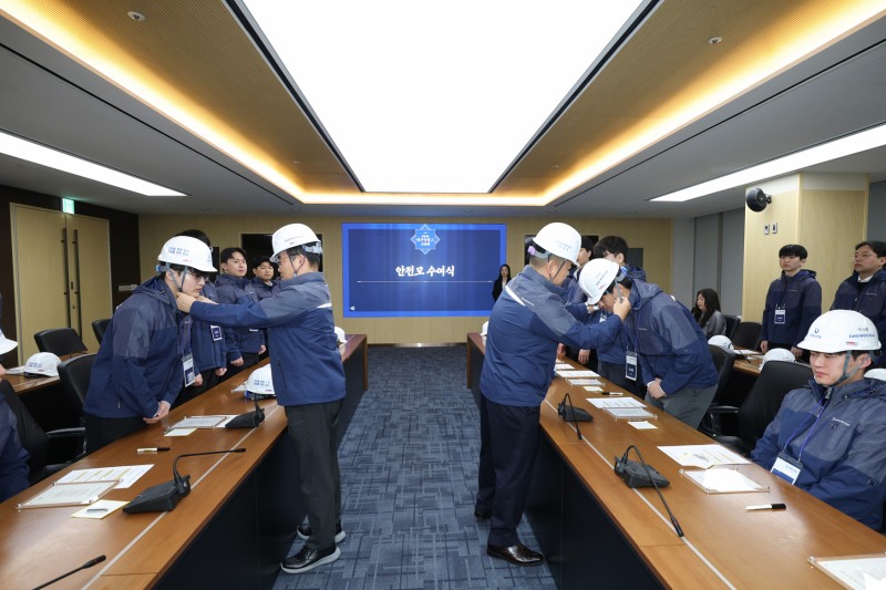 김보현 대표이사(왼쪽)와 심상철 노동조합 위원장(오른쪽)이 신입사원에게 안전모를 씌워주고 있다.(사진=대우건설)