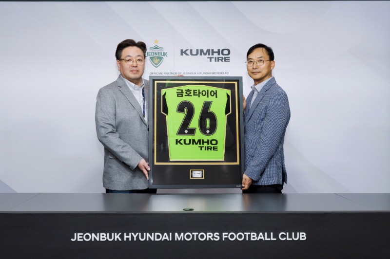 (오른쪽부터) 금호타이어 G.마케팅담당 윤민석 상무와 전북현대모터스 이도현 단장이 공식 파트너십 연장 조인식을 체결하며 금호타이어 로고가 적용된 유니폼 액자를 들고 기념사진을 찍고 있다.(사진=금호타이어)