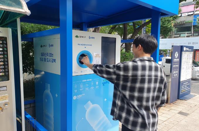 한 구민이 투명페트병 무인회수기에 페트병을 투입하고 있다.