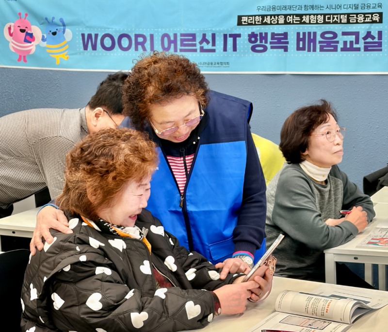 ‘우리 어르신 IT 행복 배움교실’ 에서 전년도 우수 수강생(강옥연님)이 보조강사로 활동하며 다른 수강생들을 돕고 있다. 사진=우리금융그룹