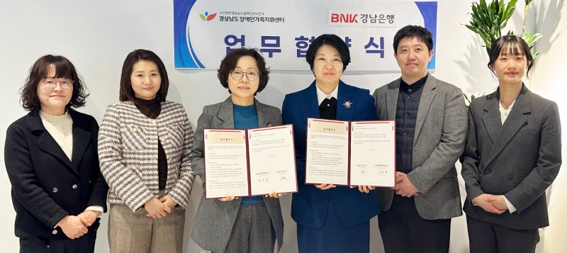 BNK경남은행 김경옥 상무(사진 오른쪽 세번째)와 경상남도장애인가족지원센터 서은경 센터장 등이 ‘금융교육 지원 업무협약’을 체결한 뒤 단체 기념촬영을 하고 있다. 사진=BNK금융그룹