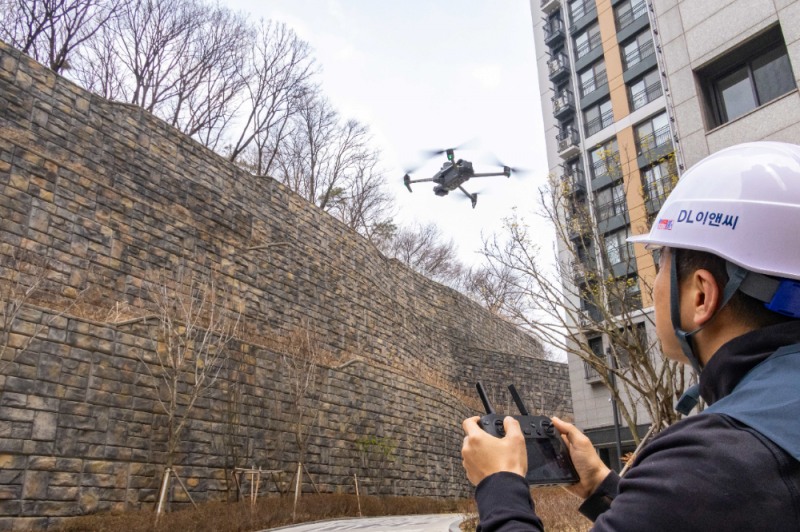 DL이앤씨 직원이 수도권의 한 아파트 입주 현장에서 육안 점검이 어려운 옹벽, 비탈면 등을 드론을 활용해 세밀하게 점검하고 있다.(사진=DL이앤씨)