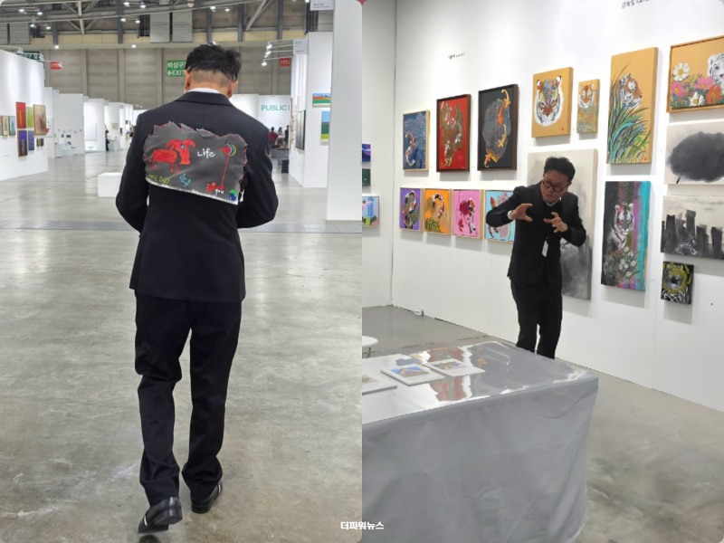 3일 오전 부산 해운대 벡스코 ‘2026 부산국제화랑아트페어(BAMA)’ 전시장에서 또우 작가(우승하)가 직접 제작한 상징물을 등에 단 채 전시장을 걷는 모습(왼쪽)과 김복일 작가의 호랑이 작품 앞에서 특유의 동작으로 셀카 영상을 촬영하는 모습 / 사진=이승렬 기자