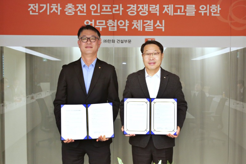 한화 건설부문 김민석 건축사업본부장(좌측)과 E1 김수근 영업본부장(우측)이 전기차 충전기 공급 및 운영을 위한 전략적 파트너십 체결하고 기념촬영을 하고 있다.(사진=한화 건설부문)