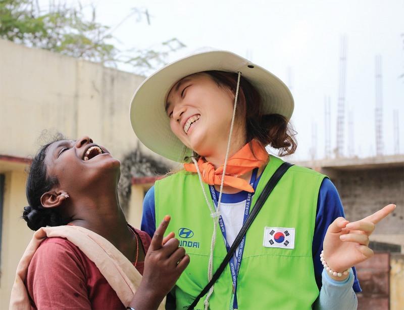 해피무브 봉사단에 참여한 자원봉사자가 현지 여성과 대화를 나누며 환하게 웃고 있다.(사진=현대차그룹)