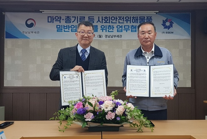 (사진왼쪽부터) 김헌주 경남남부세관장과 김기호 ㈜유경CM대표가 업무협약서를 내보이며 기념촬영.(사진제공=경남남부세관)