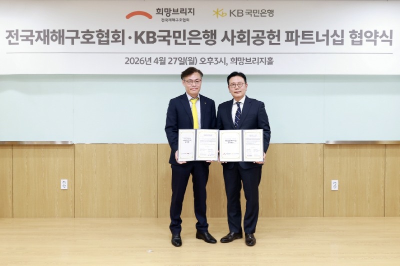 지난 27일 서울 마포구 소재 희망브리지 전국재해구호협회에서 열린 협약식에 참여한 김영일 KB국민은행 기관영업그룹 부행장(왼쪽)과 신훈 희망브리지 전국재해구호협회 사무총장(오른쪽)이 기념촬영을 하고 있다. 사진=KB국민은행