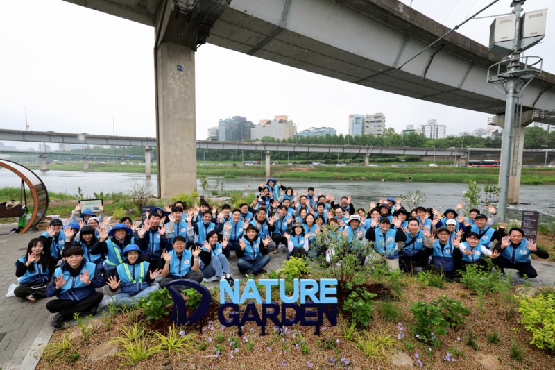 대우건설 임직원들이 준공한 ‘대우건설 Nature’ 정원에서 사진촬영을 하고 있다.(사진=대우건설)