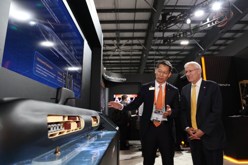캐나다 오타와에서 열린 ‘CANSEC 2026’ 전시회 내 한화오션 부스에서, 한화오션 특수선해외사업단장 정승균 부사장(왼쪽)이 빅터 피델리 온타리오주 경제개발부 장관에게 최신예 잠수함인 KSS-III 모델을 소개하며 그 우수성을 설명하고 있다.(사진=한화오션)