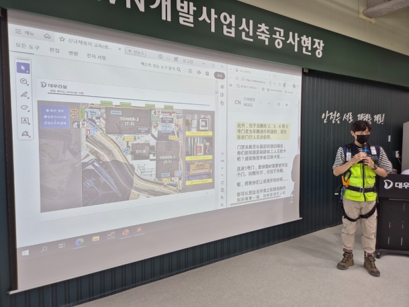 대우건설 관계자가 과천 G-TOWN 개발사업 신축공사 현장에서 외국인 근로자를 위한 AI 번역기 기능에 대해 교육 중이다.(사진=대우건설)