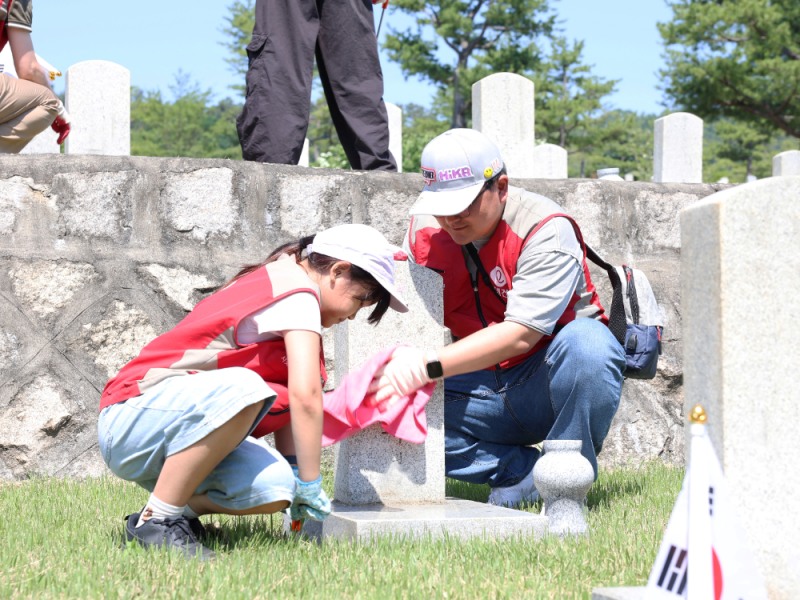 롯데건설 ‘샤롯데 봉사단’이 지난달 30일 서울 동작구에 위치한 국립서울현충원 20번 묘역에서 비석을 닦고 태극기를 꽂는 등 봉사활동을 하고 있다.(사진=롯데건설)