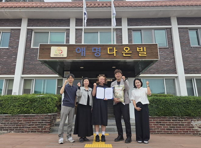 사회봉사명령을 받은 미용사가 이미용 봉사로 받은 표창장을 내보이며 기념촬영을 하고 있다.(사진제공=안동보호관찰소)