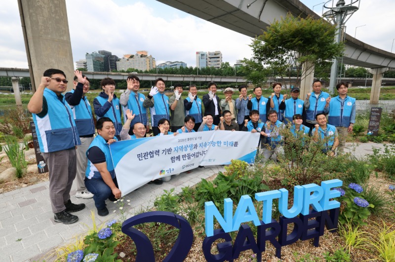봉사활동 참석자들이 '대우건설 Nature' 앞에서 기념촬영을 하고 있다.(사진=대우건설)
