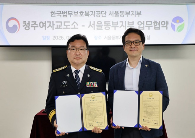 김봉영 소장과 정순찬 지부장이 6월 11일 업무협약서를 내보이며 기념촬영.(사진제공=청주여자교도소)