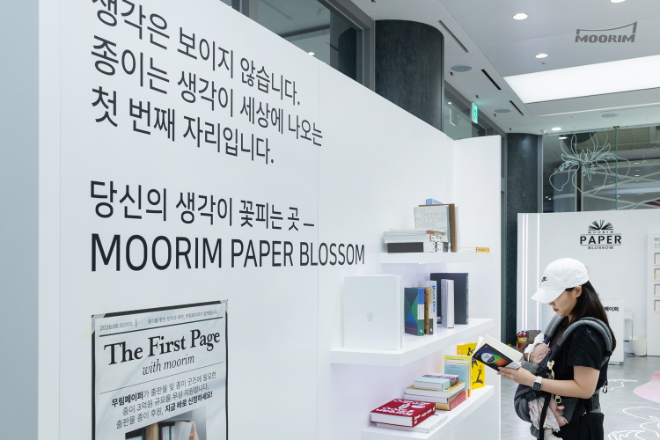 ‘무림페이퍼 블라썸’ 전시존에서 아이와 함께 방문한 관람객이 무림 인쇄용지로 제작된 책을 읽어보며 종이의 가치를 경험하고 있다. / 사진제공=무림페이퍼
