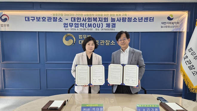 (사진왼쪽부터) 박미향 센터장과 김기환 소장이 6월 23일 업무협약서를 내보이며 기념촬영을 하고 있다.(사진제공=대구보호관찰소)