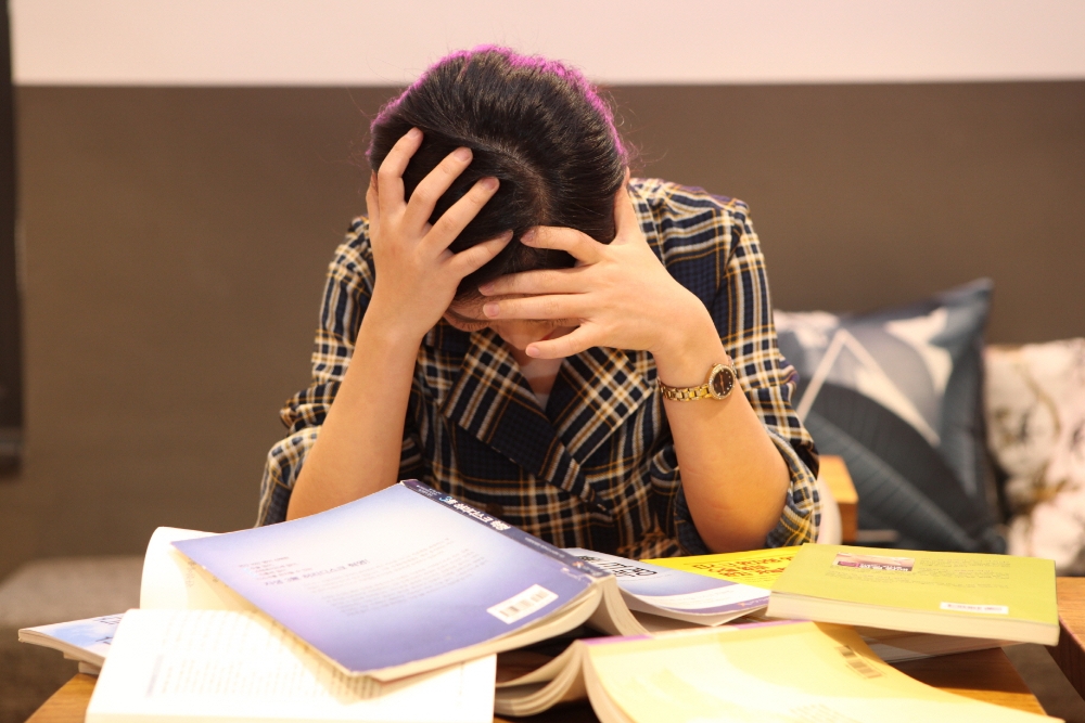 한 직장인 여성이 스트레스로 머리를 감싸 쥐고 있다.(사진=자생한방병원)