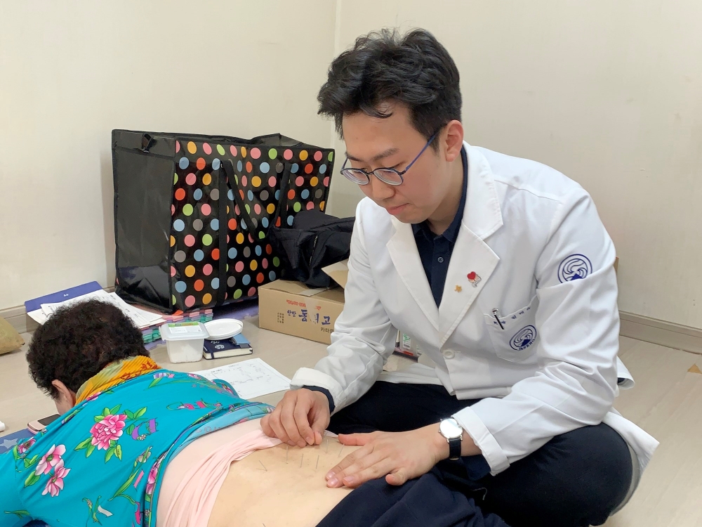 자생한방병원 의료진이 경로당 진료소를 찾은 환자에게 침 치료를 시행하고 있다. (사진=자생한방병원)