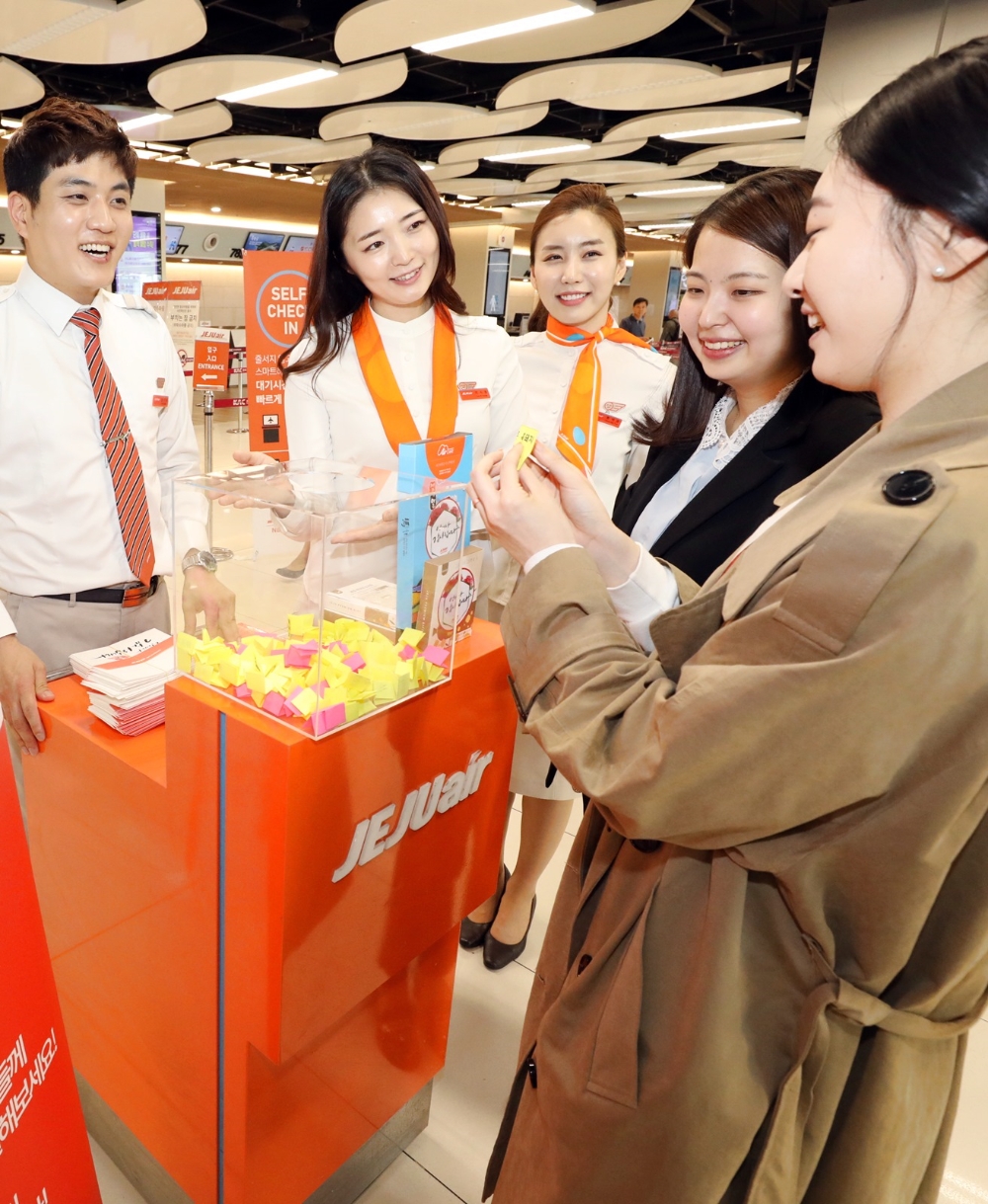 5월8일 어버이날을 맞아 제주항공 승무원들이 김포공항 국내선 2층 카운터에서 여행객들에게 캘리그라피 감사봉투를 나눠주고 럭키드로우 이벤트를 진행하고 있다. (사진=제주항공)
