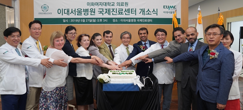 김선종 국제진료센터장(왼쪽 1번째), 문병인 의료원장(왼쪽 10번째), 백남선 국제의료사업단장 등 관계자들이 국제진료센터 개소를 축하하며 떡 컷팅을 하면서 기념 사진을 촬영하고 있다. (사진=이대서울병원)