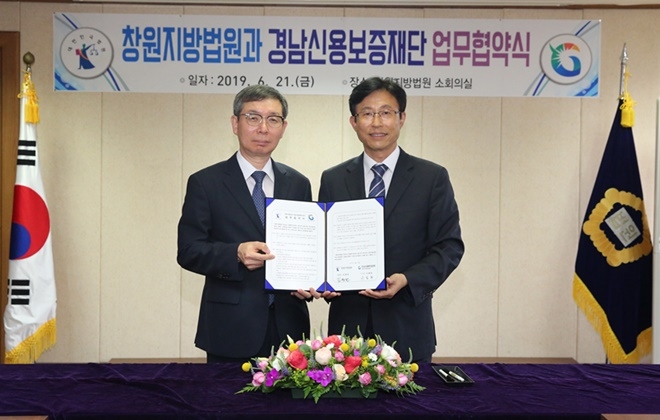 김형천 법원장(사진왼쪽)과 구철회 이사장이 업무협약서를 내보이며 기념촬영.(사진제공=창원지방법원)