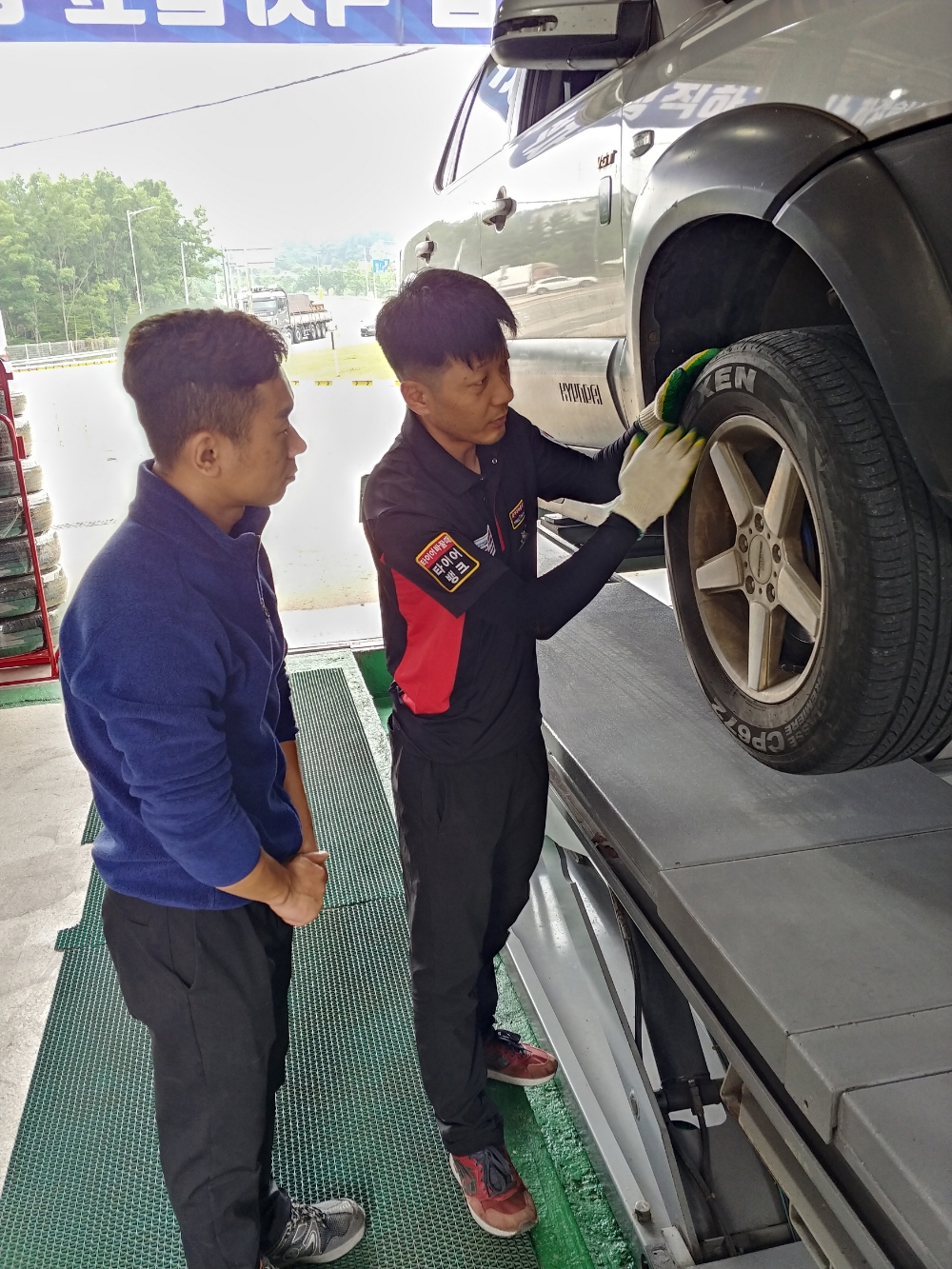 여름 비온 뒤 타이어 휠이 부식하면 타이어에 치명적인 위험을 제공하는 원인이 될 수 있다. 국지성 호우 예보가 중부권에 내린 가운데 타이어 점검을 받는 운전자들의 발걸음도 바빠지고 있다. 충남 당진시 송악읍 서해안 고속도로 당진 IC에 위치한 타이어뱅크 당진 IC점 황윤석 사업주가 방문 고객에게 여름철 휠 상태를 점검하며 부식과 비온 뒤 자가 확인법을 설명해 주고 있다.(사진=타이어뱅크)