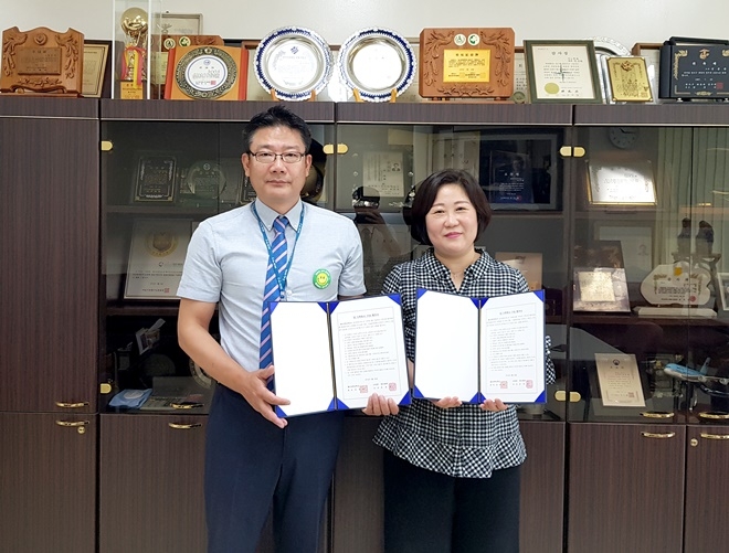 윤영한 총무부장과 한미라 교수가 업무협약서를 내보이며 기념촬영.(사진제공=부산영도병원)