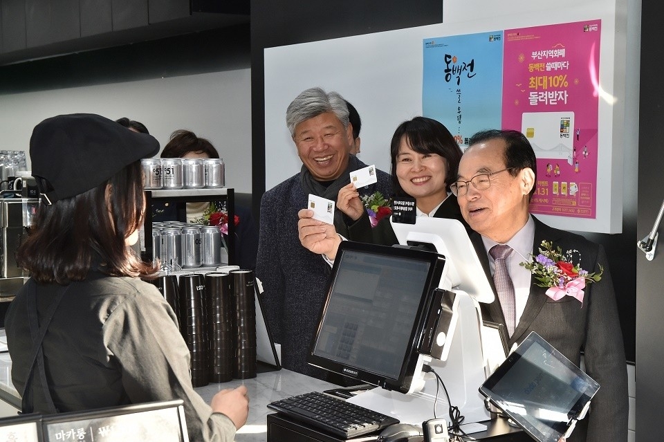 오거돈 부산시장(오른쪽 첫째)과 박인영 부산시의회 의장(오른쪽 두번째)이 지난해 30일 부산시가 출시한 지역화폐 ‘동백전’을 사용하고 있다. (사진제공=부산시)