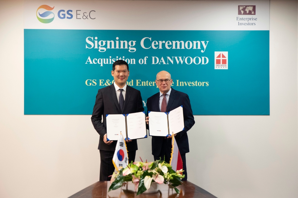 허윤홍 GS건설 사장이 20일(현지시각) 폴란드 단우드 본사에서 열린 인수 축하 행사에서 야첵 스비츠키 단우드 사장과 함께 인수를 마무리하는 서류에 서명 후 기념촬영 하고 있다.(사진=GS건설)