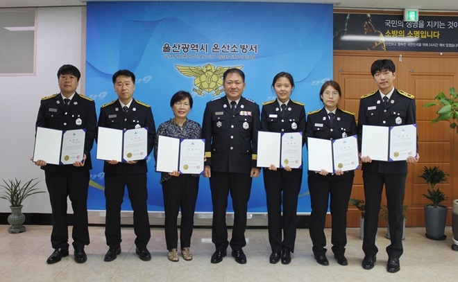 윤태곤 서장이 시민과 구급대원에게 하트세이버 인증서를 수여하고 기녀촬영.(사진제공=울산온산소방서)