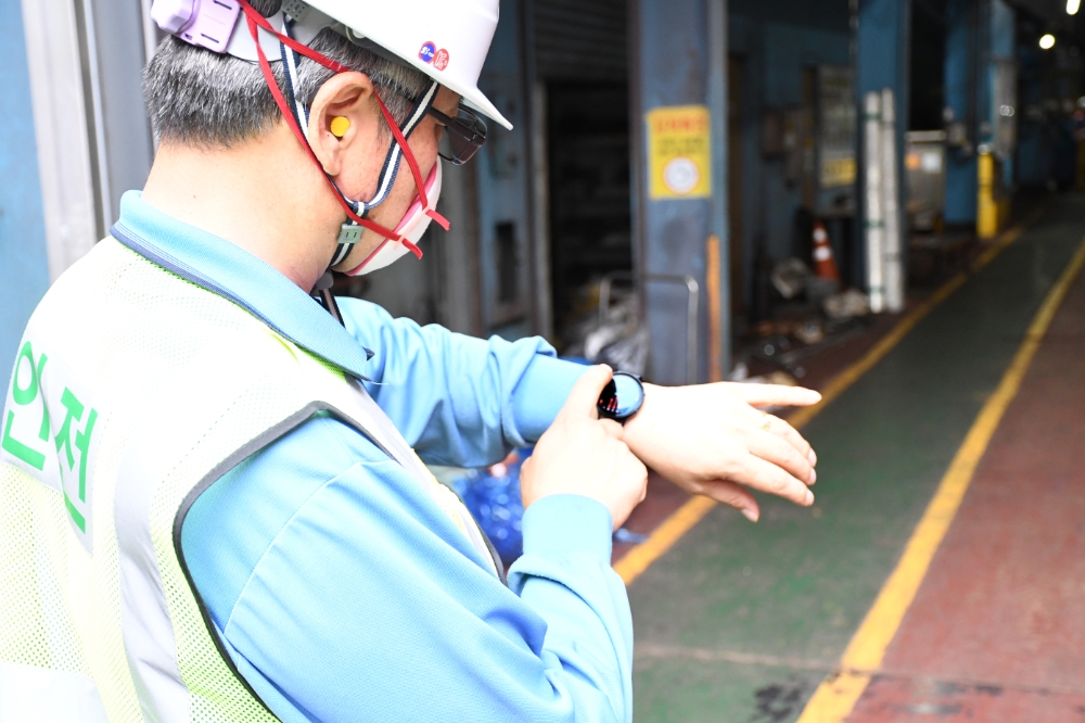 포스코 포항제철소 후판부 직원이 현장 순찰하며 스마트워치로 심박을 확인하고 있다.(사진=포스코)