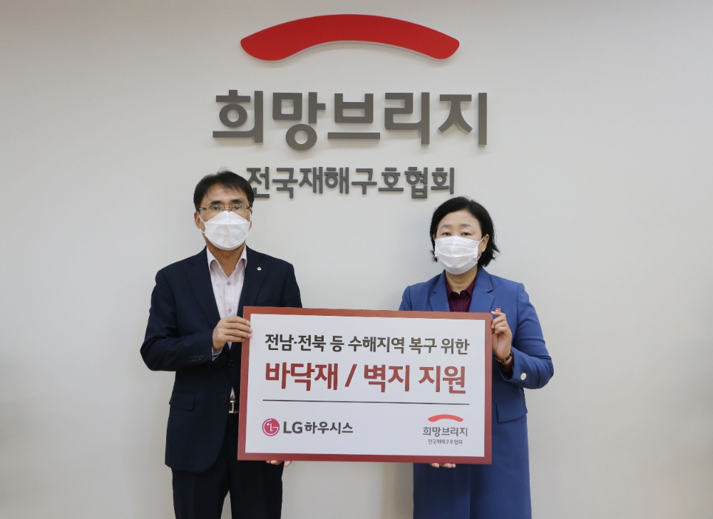 29일 서울 마포구 희망브리지 전국재해구호협회에서 LG하우시스 장식재사업부장 박귀봉 전무(사진 왼쪽)와 희망브리지 전국재해구호협회 김정희 사무총장이 수해복구 자재 전달식 후 기념촬영을 하고 있는 모습.(사진=LG하우시스)