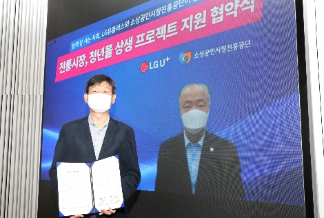 27일 용산사옥 1층 다목적홀 ‘U+Seer 라운지’에서 (사진 왼쪽)황현식 LG유플러스 사장이 소상공인시장진흥공단 조봉환 이사장과 화상회의를 통해 비대면으로 전통시장∙청년몰 활성화 지원을 위한 업무협약을 체결하는 모습. 사진=LG유플러스
