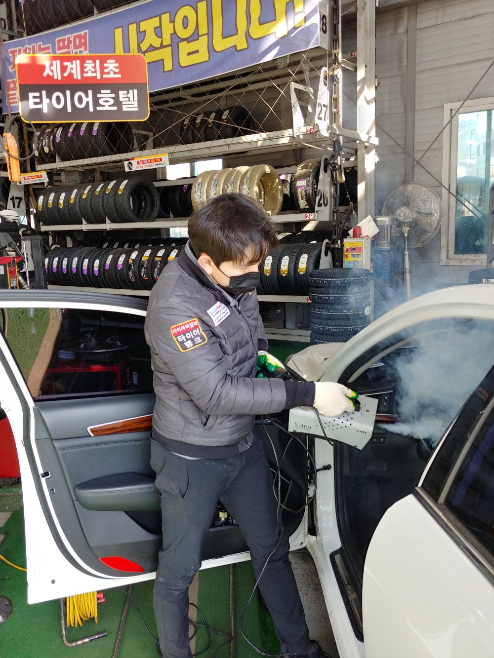 경기도 안양시 만안구 석수동에 위치한 타이어뱅크 북안양점 윤효준 사업주가 타이어 점검차 방문한 고객의 차량 내부를 소독하고 있다.(사진=타이어뱅크)