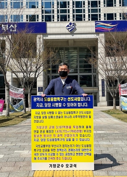 오규석 기장군수는 국토교통부와 부산시에서 추진 중인 도심융합특구 지정절차와 관련해 3월 25일 낮 12시 점심시간을 이용해 부산시청 앞에서 1인 시위를 진행하며, 기장군 동남권 방사선 의·과학 일반산업단지 일원에 도심융합특구가 유치가 되어야 할 당위성과 필요성을 강력히 호소하고 있다.(사진제공=부산 기장군)