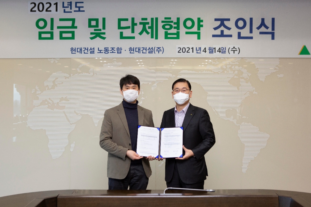 윤영준 현대건설 대표이사(사진 오른쪽)와 김준호 노조위원장(사진 왼쪽)이 협약서에 서명한 후 기념사진을 찍고 있다.(사진=현대건설)