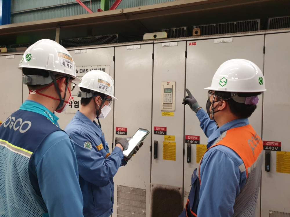 포스코 설비관리 담당 직원들이 Drive 패널 앞에서 태블릿으로 POINT 시스템에 접속해 이상 조치 방법을 학습하고 있다.(사진=포스코)
