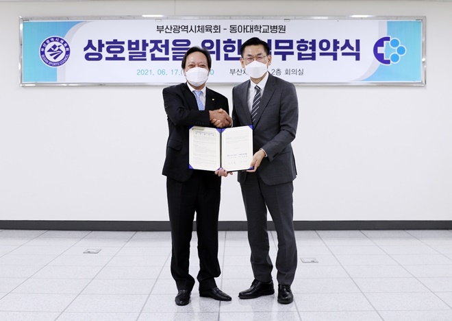 6월 17일 부산시체육회 장인화 회장(사진왼쪽)과 동아대병원 안희배 원장이 협약서를 내보이며 기념촬영.(사진제공=동아대학교병원)