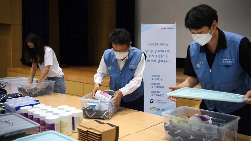 포스코건설 한성희 사장(가운데)이 임직원들과 함께 6.25 참전 유공자를 위한 폭염 피해방지 키트를 제작하고 있다.(사진=포스코건설)