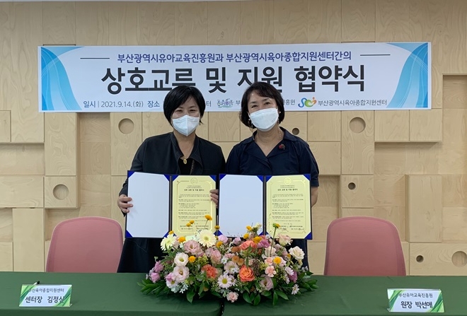 부산유아교육진흥원은 14일 부산육아종합지원센터와 업무협약서를 내보이며 기념촬영.(사진제공=부산교육청)